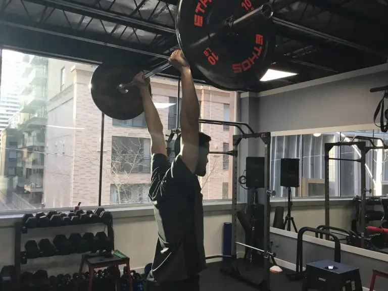 Entrenador personal levantando unas pesas